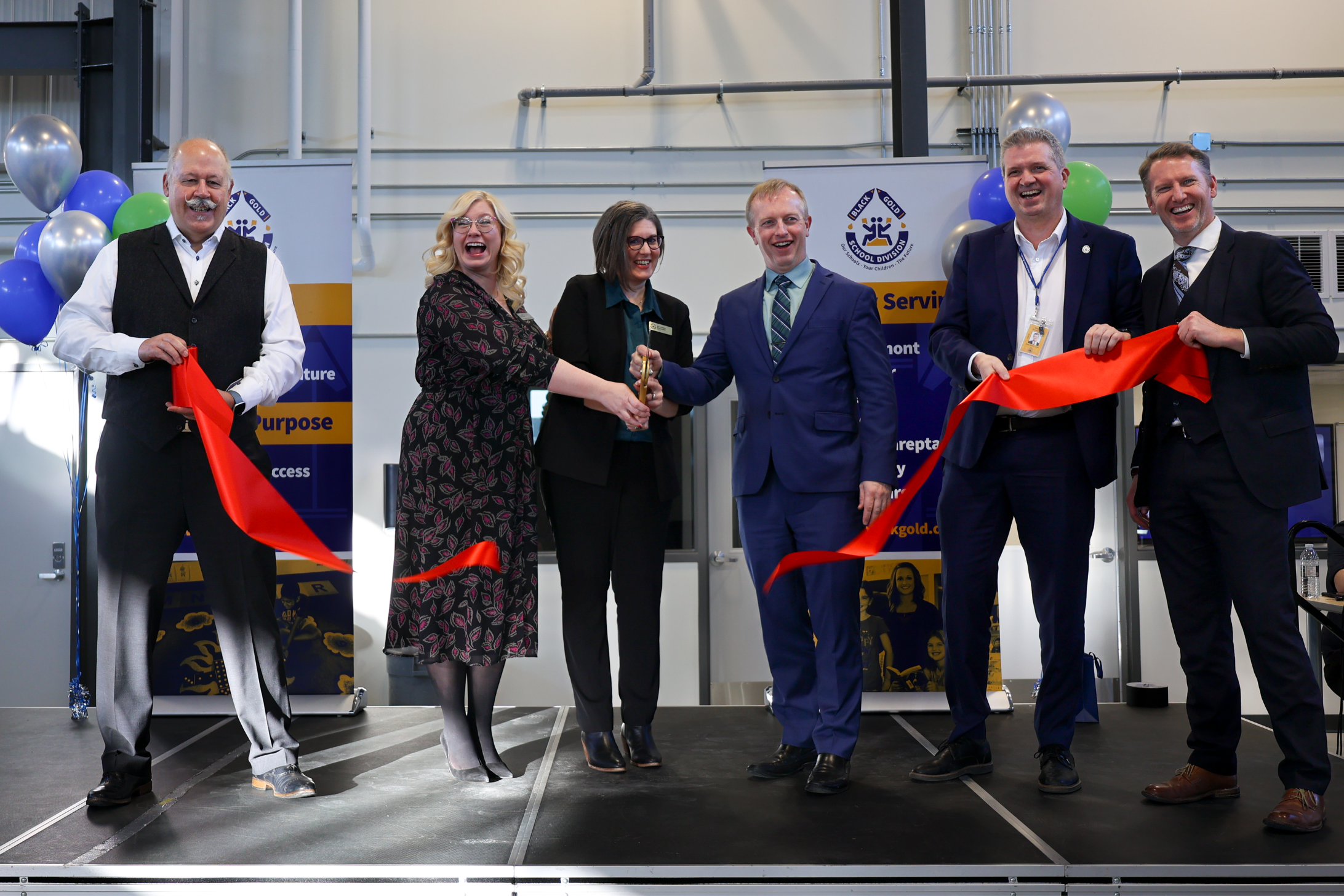 Superintendents, principal, board chair, mayor and Minister of Infrastructure cut the ribbon to open the new facility